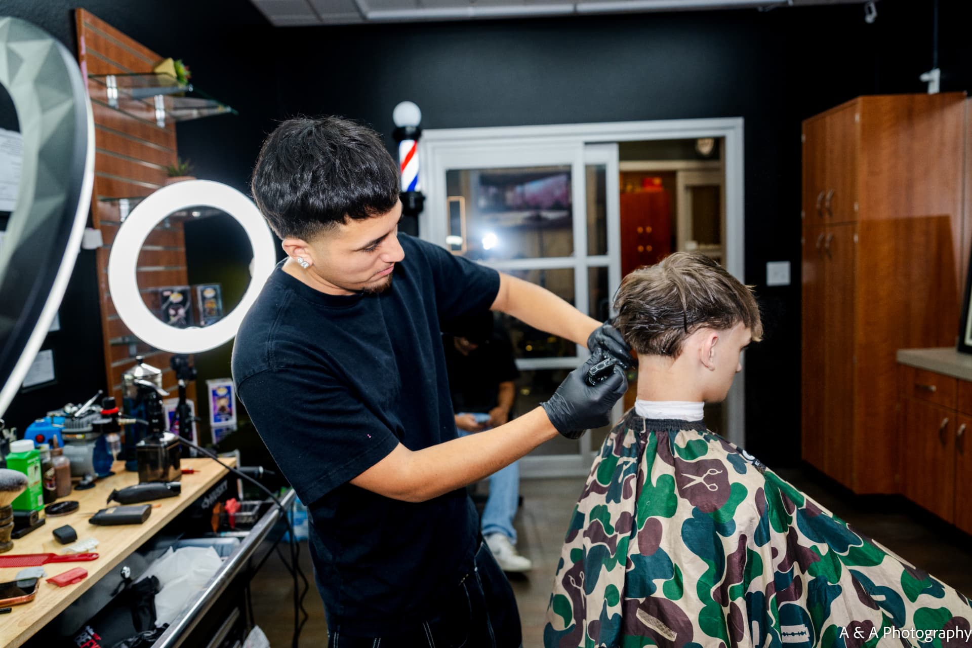 Barber cutting a client's hair in the shop chair