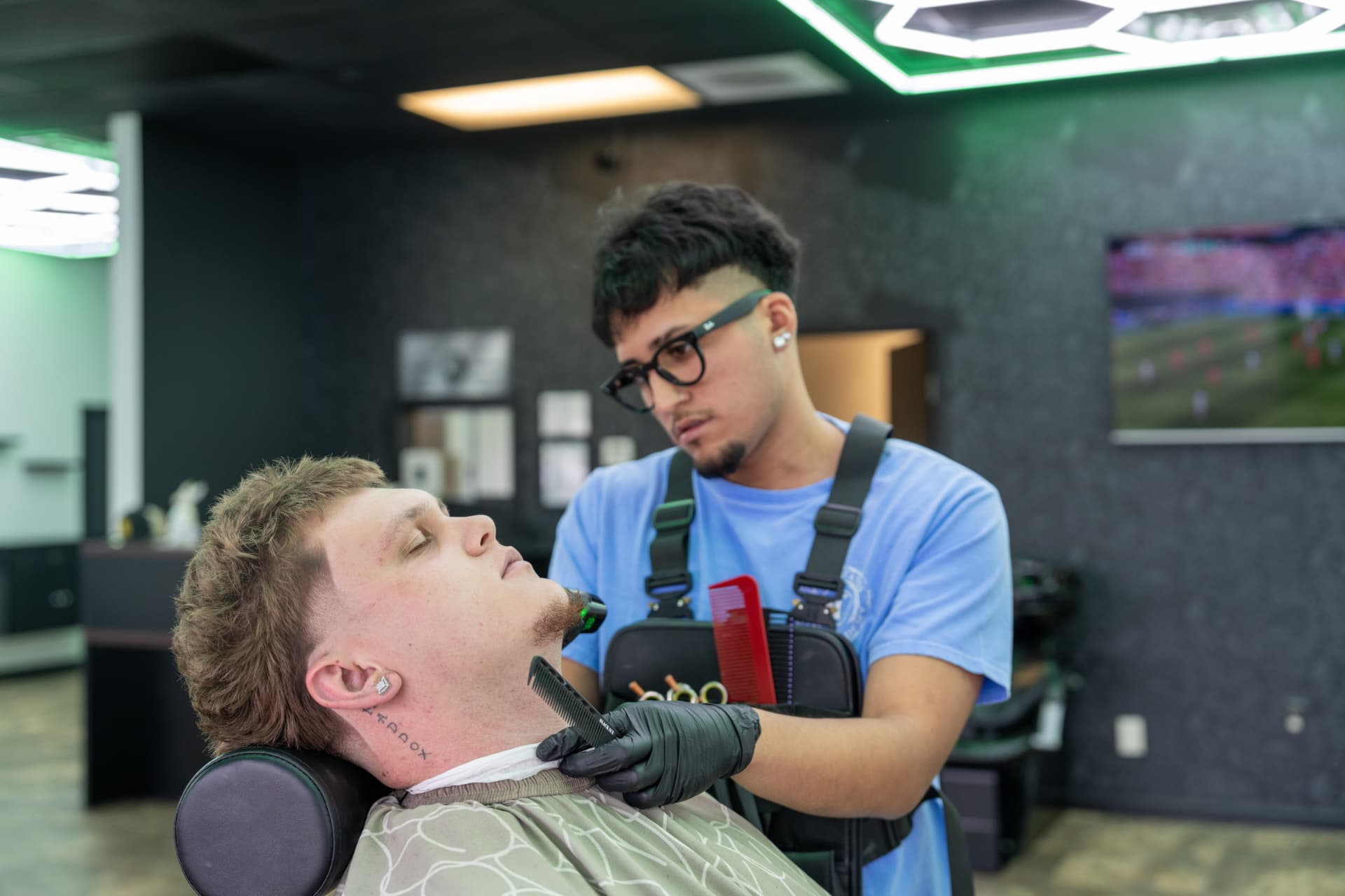 Barber detailing a client's beard and lineup